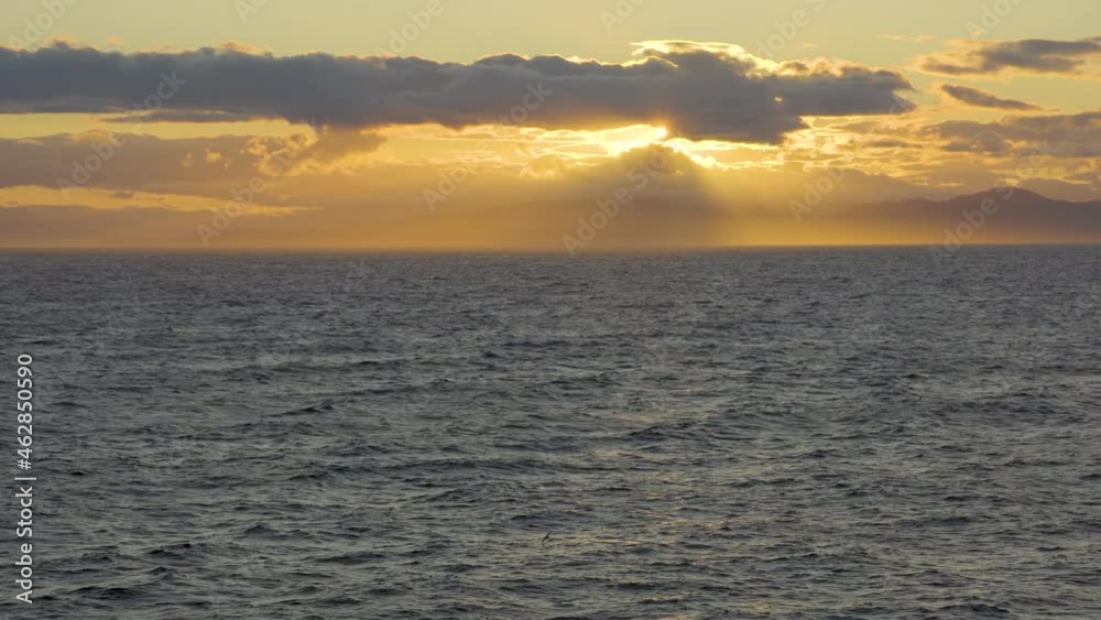 Coast of the Kamchatka Peninsula in Russia. View of the Kamchatka mountains from the sea at sunset. Beautiful sunset at sea. Coast of the Kamchatka Peninsula in Russia. View of the Kamchatka mountains from the sea at sunset. Beautiful sunset at sea.