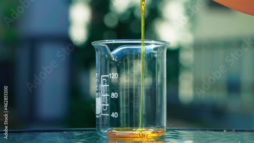  pouring orange emulsion to beaker bokeh background slow motion 100fps