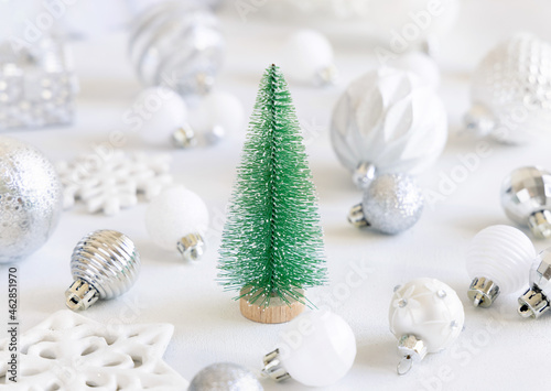 Green toy Christmas tree with white and silver Christmas decorations