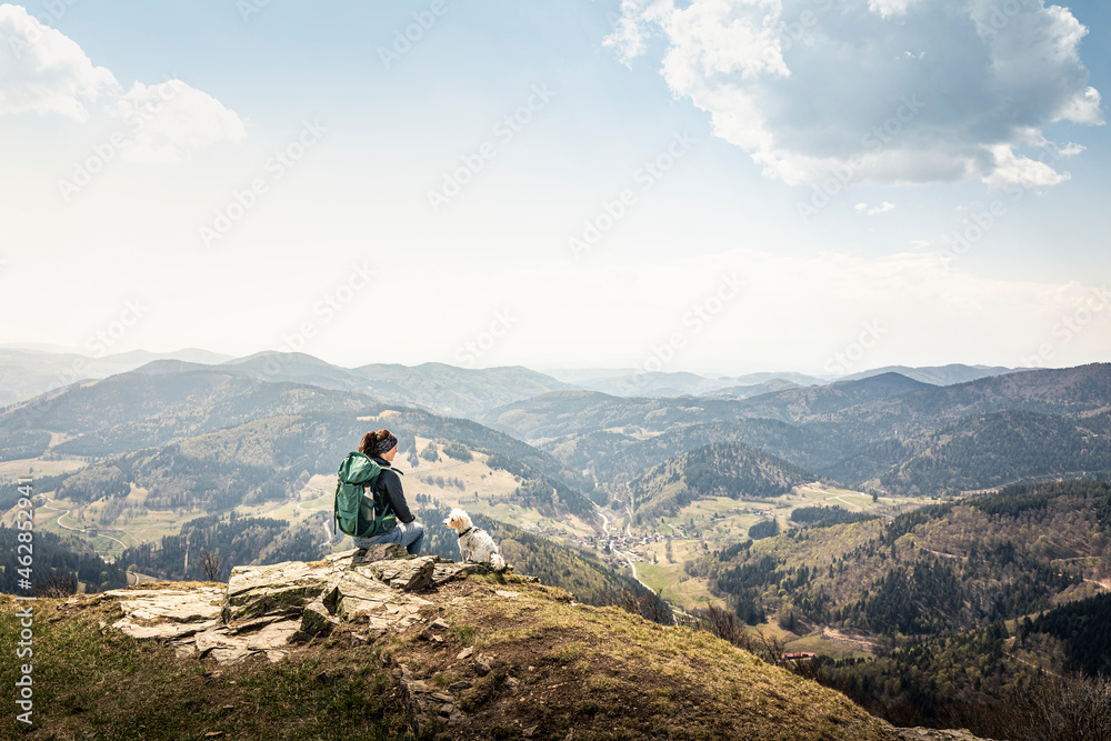 Female hiker looking at view while sitting on Kandel Mountain at Baden-Wurttemberg, Germany Female hiker looking at view while sitting on Kandel Mountain at Baden-Wurttemberg, Germany
