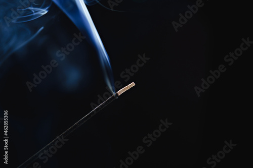 smoke from an aromatic stick on a black background.