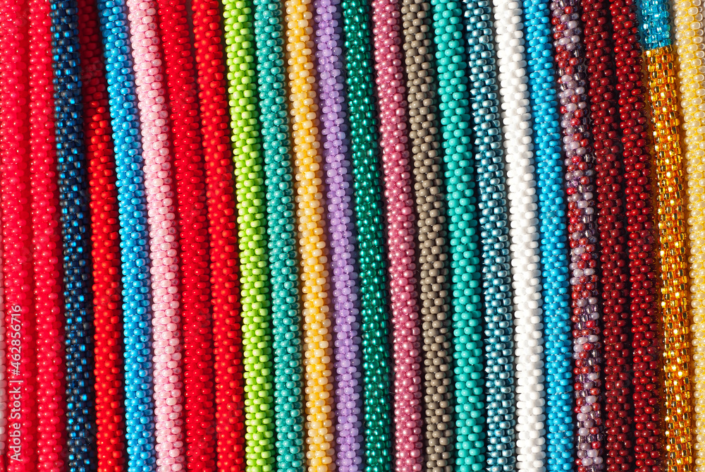 Necklace of colorful stones on the table. Many different jewelry and beads made of natural precious minerals. Beaded jewelry is on sale at the fair. Necklace of colorful stones on the table. Many different jewelry and beads made of natural precious minerals. Beaded jewelry is on sale at the fair.