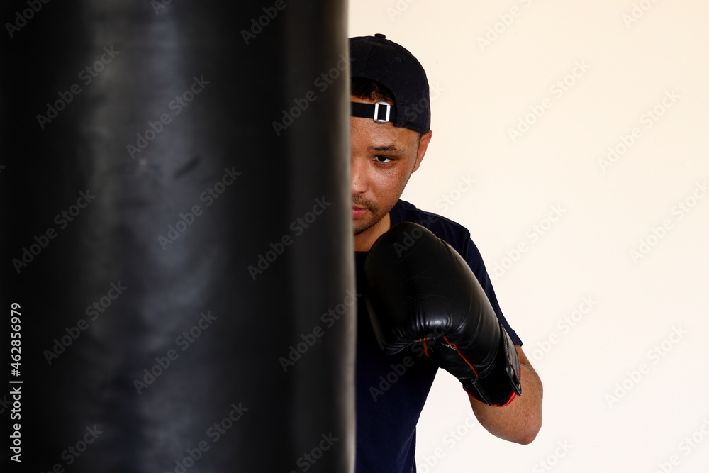 A young man hitting a punch bag.