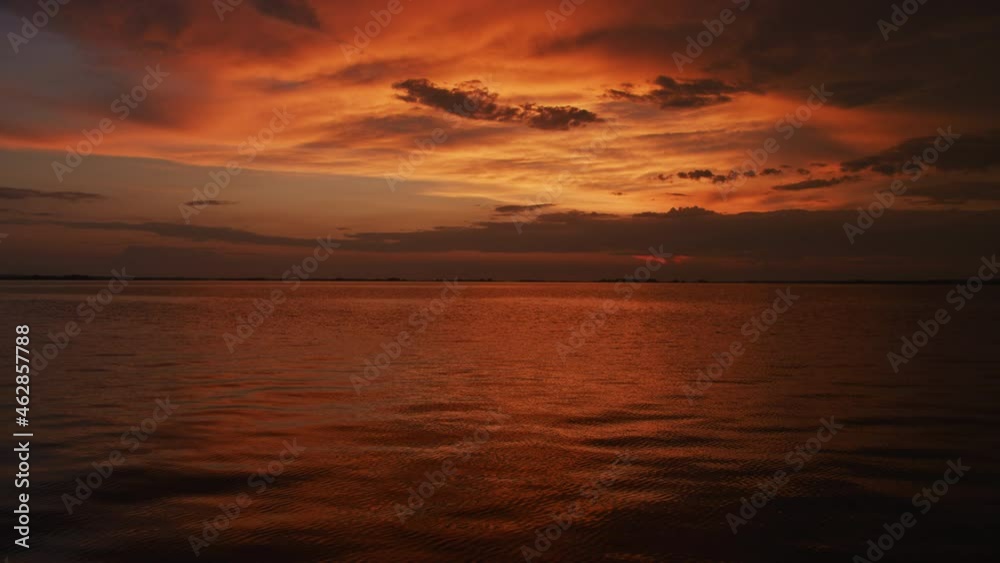 Static wide angle shot of a golden sunset on a river Static wide angle shot of a golden sunset on a river