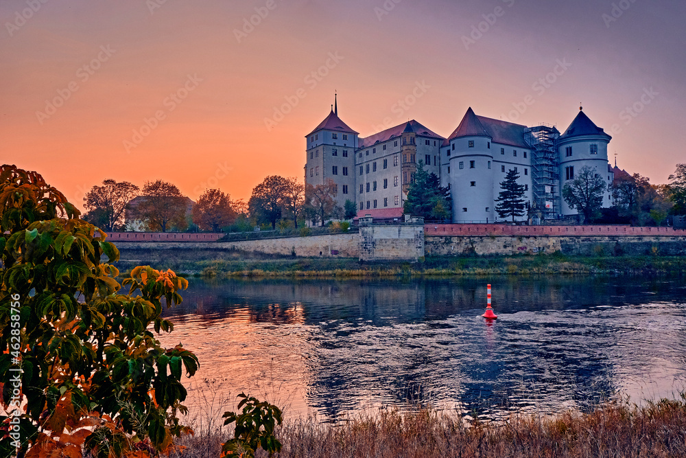 Das Schloss Hartenfels im Sonnenuntergang am Ufer der Elbe in Torgau.