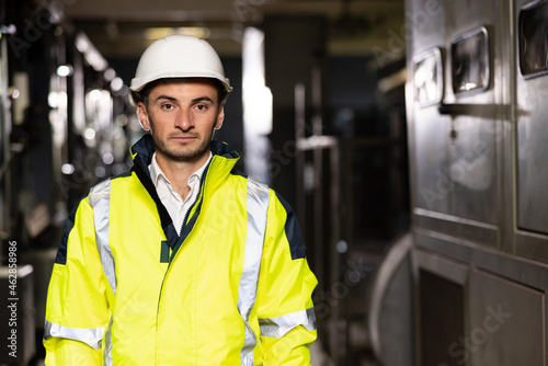 Portrait of a frontline essential worker in a warehouse. Caucasian business people in hard hat or safety wear. Professional male industry engineer specialist photo