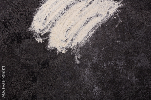 white flour on a black structural background. The beginning of cooking. Process.