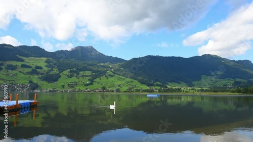 Footage of beautiful mountains landscape with Lake Lauerz and swan in Switzerland Alps photo