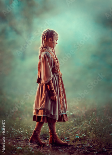 Girl with braids in beige clothes in the autumn forest