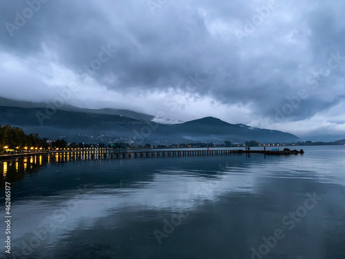 Wallpaper Mural Long pier at the lake, twilight, dark blue and gray sky and lake, mountains background Torontodigital.ca