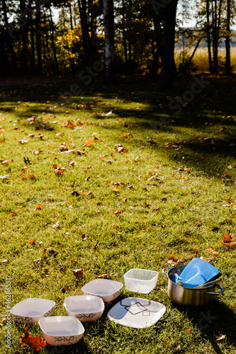 kempingowe naczynia suszące sie na trawie w słońcu, kemping w letni słoneczny dzień