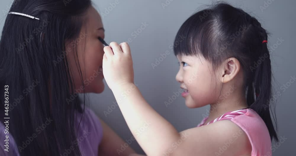 4K Video slow motion Asian little daughter doing make up her mom. Concept of love and connection of mother and kid. 4K Video slow motion Asian little daughter doing make up her mom. Concept of love and connection of mother and kid.