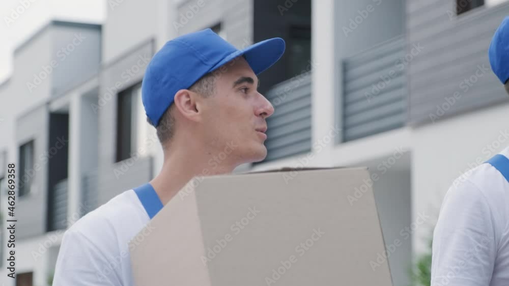 Two young workers of removal company deliver boxes to a customer's home Two young workers of removal company deliver boxes to a customer's home