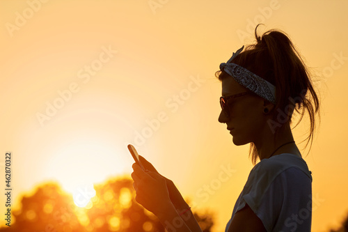 Female using modern smartphone outdoors. © astrosystem