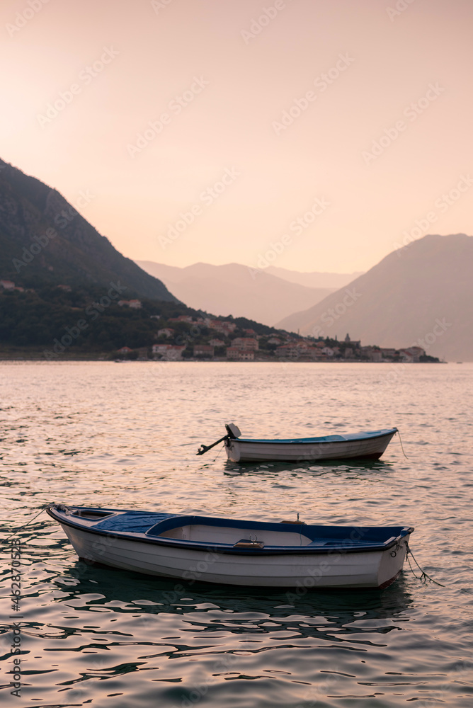 Beautiful Bay and mountains with two moored boats without people on evening sky