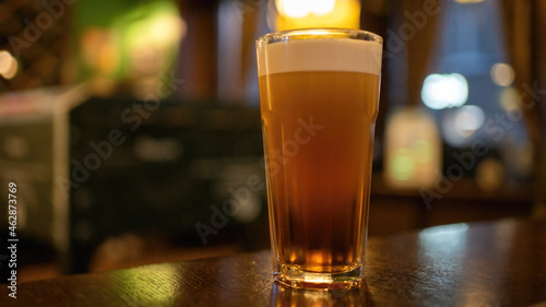 Glass of beer with foam at the bar.