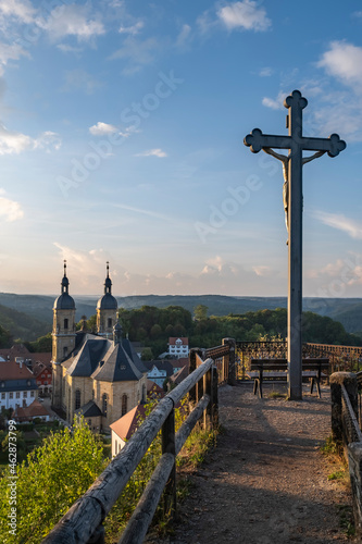 Foto View of the basilica of Gößweinstein / Germany at sunset with a cross in the for