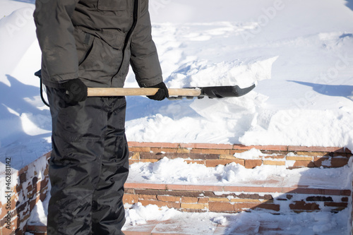 Snow clearing, shovel in hand and snow removal on the steps of the territory