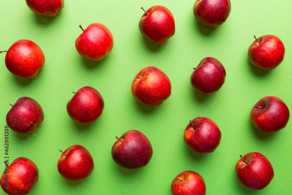 Many red apples on colored background, top view. Autumn pattern with fresh apple above view Many red apples on colored background, top view. Autumn pattern with fresh apple above view