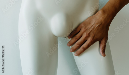 man touches the groin of a mannequin