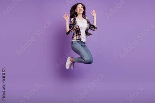 Full length photo of young crazy girl happy positive smile jump up fly air isolated over violet color background