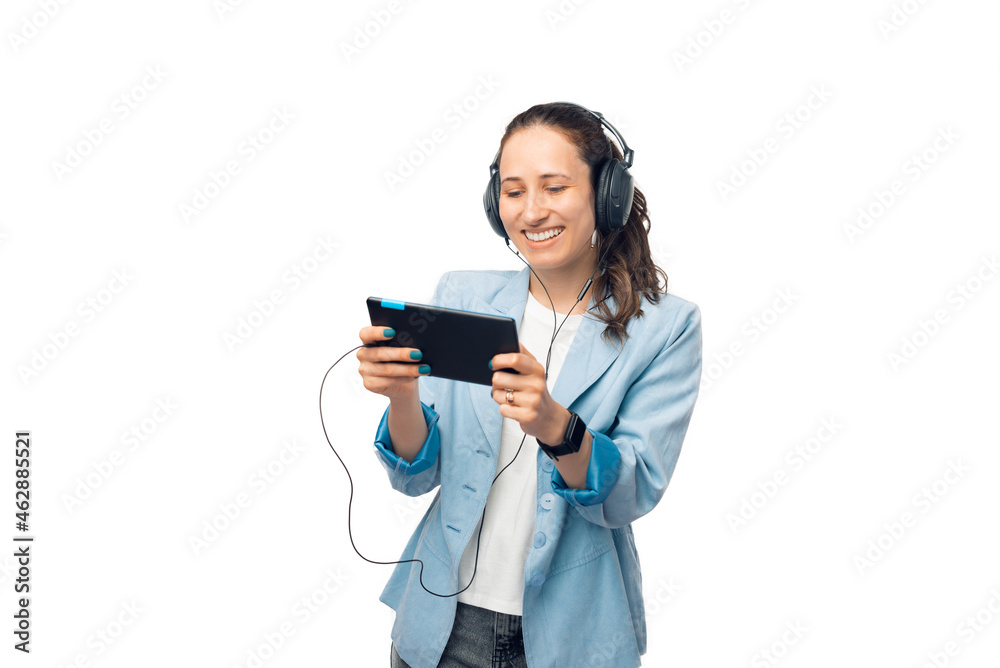 Smiling young lady is watching something on the tablet and listening in headphones. Smiling young lady is watching something on the tablet and listening in headphones.