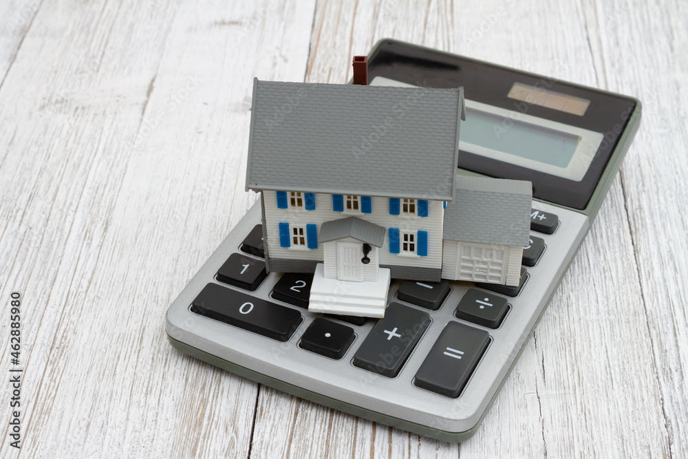 Model house with a calculator on wood desk Model house with a calculator on wood desk