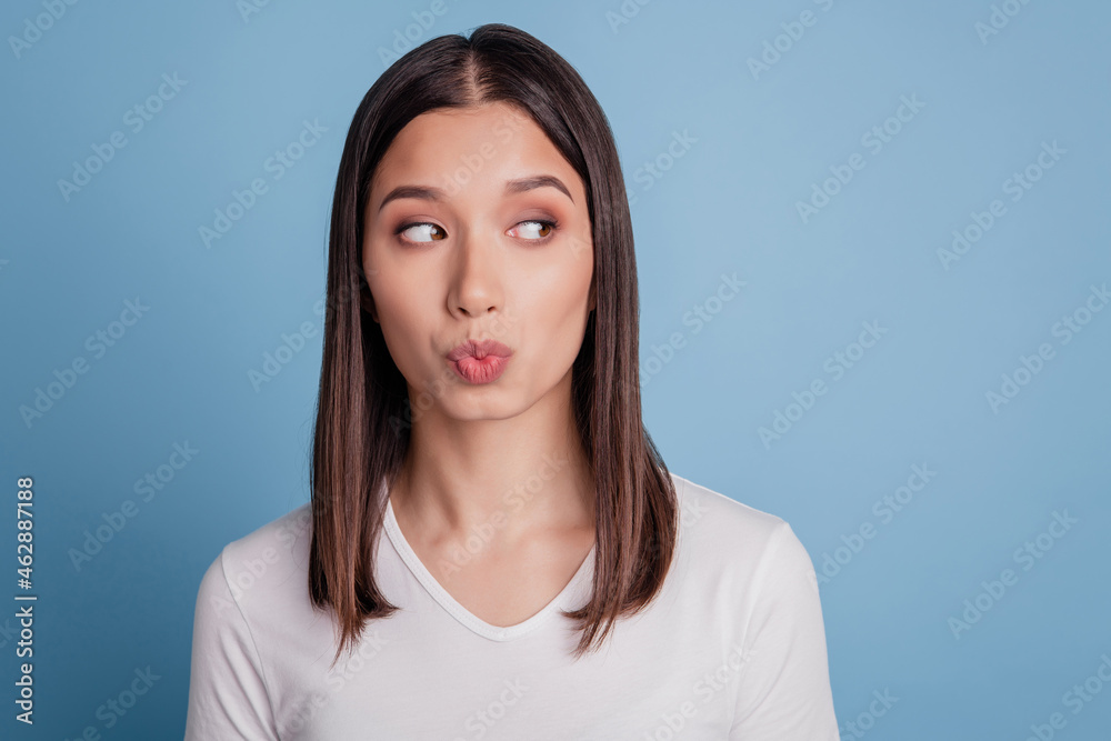Closeup photo of attractive young woman sending air kisses romantic flirty look empty space isolated blue color background Closeup photo of attractive young woman sending air kisses romantic flirty look empty space isolated blue color background