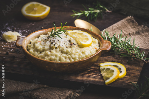 Fotografía Lemon rice risotto with rosemary on dark wooden background