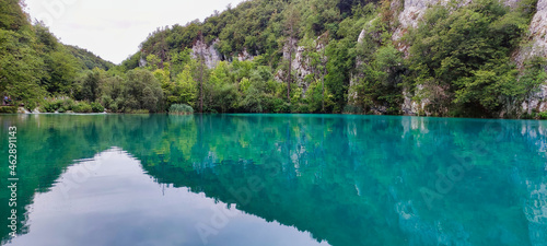 View of the lake and nature in the Plitvice Lakes National Park. Green water. Mountains in the background. Overcast weather. Croatia. Europe