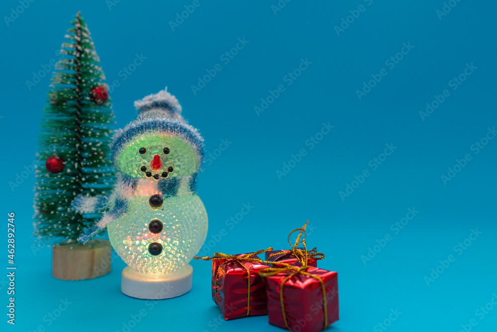 Glows in the dark snowman, presents and Christmas tree with copy space.new year celebration. Glows in the dark snowman, presents and Christmas tree with copy space.new year celebration.