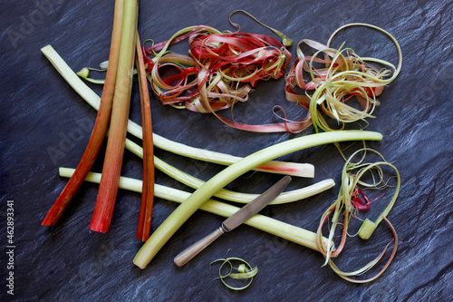Peeled and unpeeled rhubarb on slate