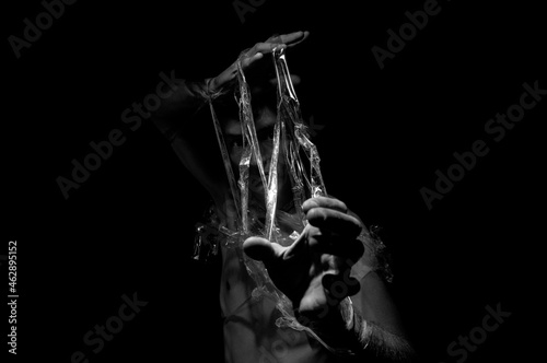 black and white photo, hands entangled in polyethylene