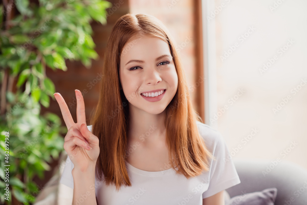 Photo of young cheerful lovely girl happy positive smile show fingers peace cool v-sign hipster indoors Photo of young cheerful lovely girl happy positive smile show fingers peace cool v-sign hipster indoors