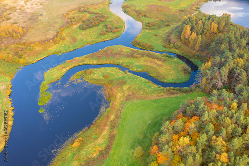 Beautiful early autumn landscape  field  river and colorful forest. Pushkinskie Gory  Pskov Region Russia. top areal view from a drone