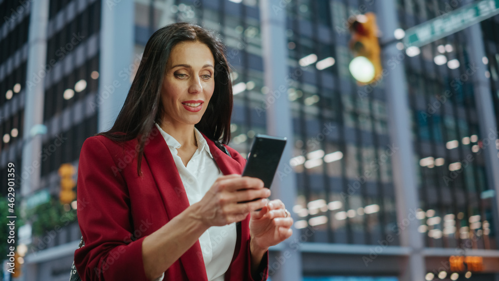 Portrait of Multiethnic Adult Businesswoman Using Smartphone on Street in a Big City. Confident Manager Connecting with People Online, Messaging, Browsing Internet on Her Way to Office.