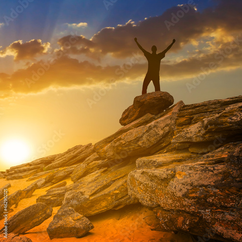 happy man silhouette stay on heap of stones at the sunset   people sport travel background