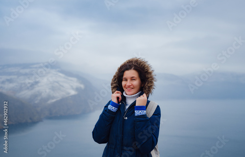 side view of woman in blue jacket and hat on shore of North sea on cold winter day. Mood Scandinavian weather. travel adventure lifestyle idea and concept