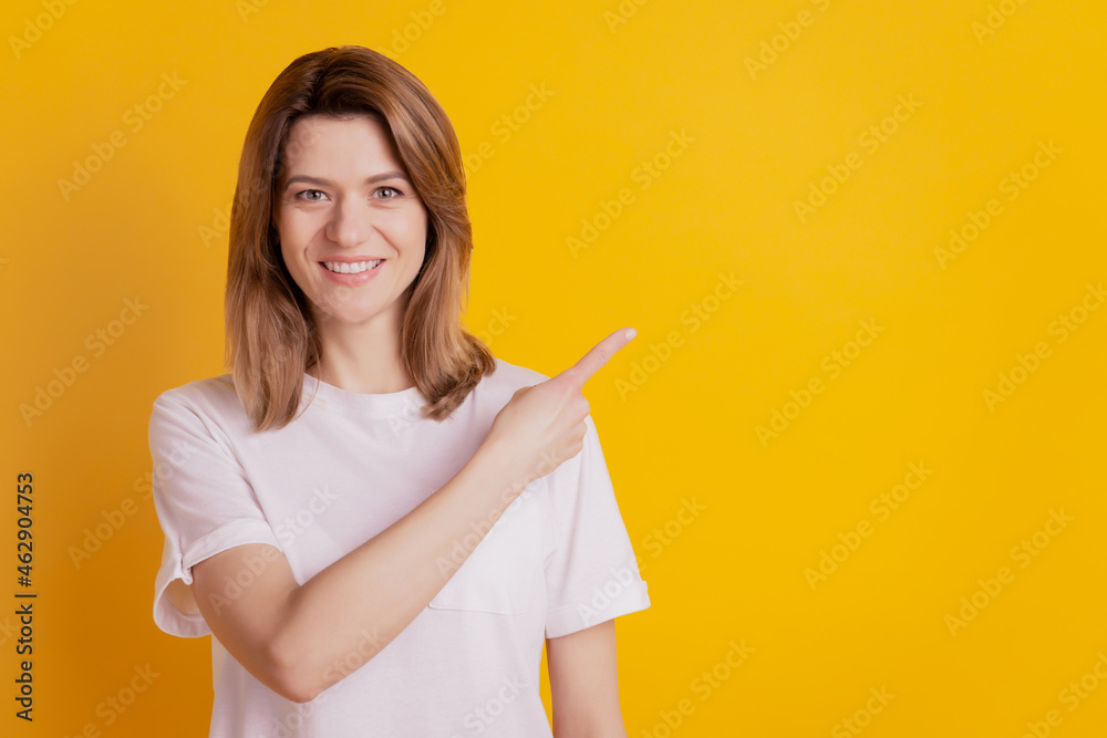 Photo of positive cheerful adviser lady direct finger empty space wear casual outfit on yellow background Photo of positive cheerful adviser lady direct finger empty space wear casual outfit on yellow background