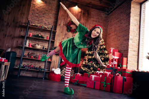 Full body photo of cheerful funky young happy woman elf hands plane wings christmas indoors inside house home