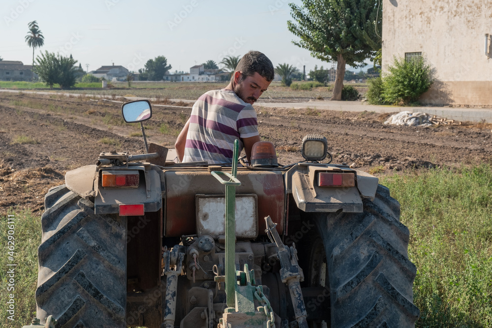 Obraz premium young farmer preparing the farm tools to start the cultivation of the orchard