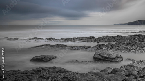 Long exposure of a rocky shoreline, on a cloudy day