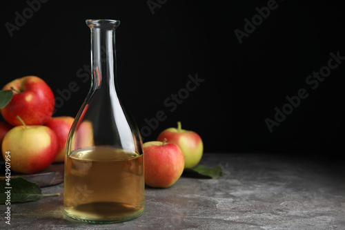 Natural apple vinegar and fresh fruits on grey table. Space for text