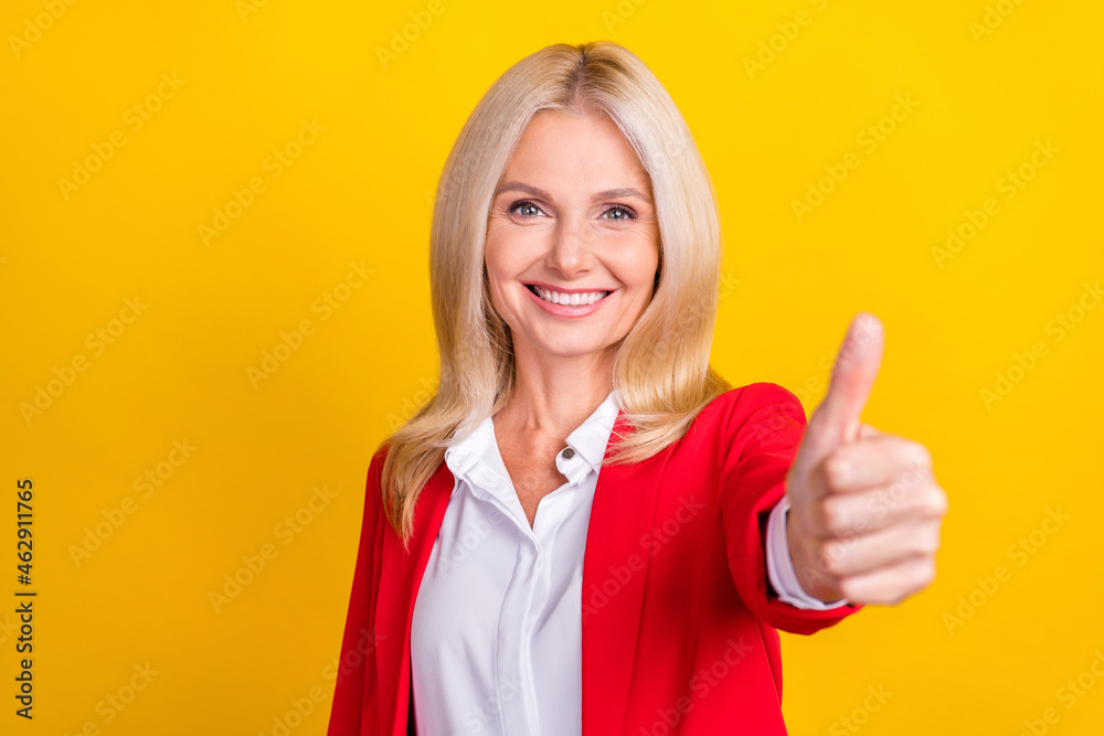 Photo of successful senior business lady show thumb-up approve great recommend isolated over yellow color background Photo of successful senior business lady show thumb-up approve great recommend isolated over yellow color background
