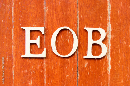 Alphabet letter in word EOB (Abbreviation of end of business) on old red color wood plate background