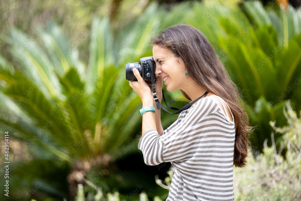 Young woman photographing with a digital camera
