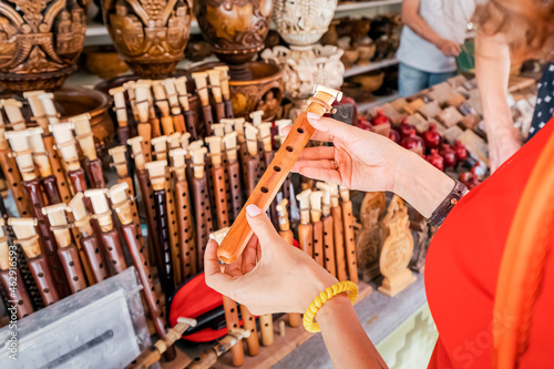 A female tourist inspects and tries to blow a duduk - a traditional Armenian musical wooden instrument at the handmade market in Yerevan