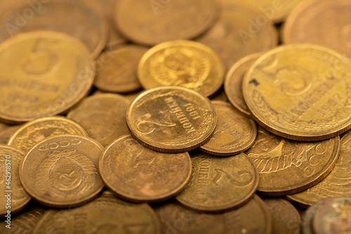 Old coins out of circulation in bulk, background image, close-up, selective focus.
