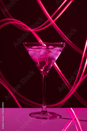 Martini glass with drink and ice against creative lighting