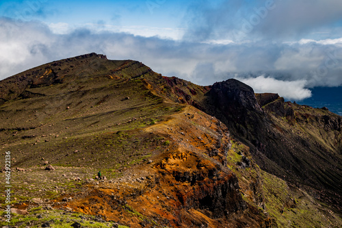 A beautiful view on mountains  sky  clouds and person figure hiking  near active volcano Aso in Kyushu  Japan